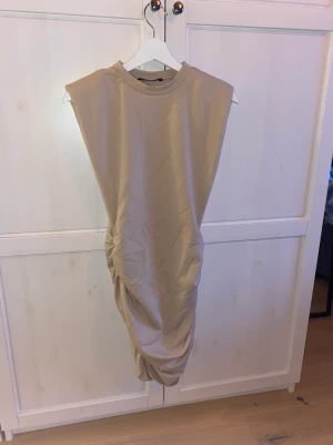 Beige klämnomg - Beige topp med vadderade armar. Fin till vardags och fest