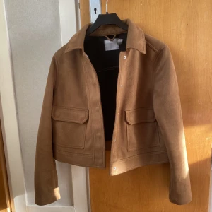 Jacka mockaimitation - Croppad jacka i mockaimitation. Nästan nytt skick. Passar en med storlek 36/38.