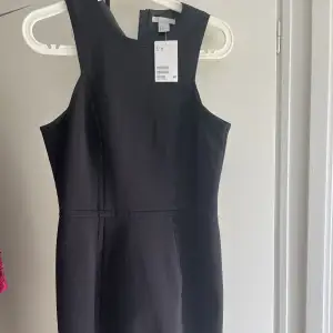 Oanvänd svart klänning från H&M. Lapparna sitter kvar.  Storlek 38