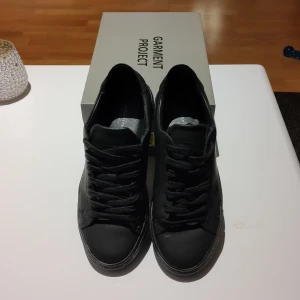 Garment Project skor - Skor endast använda 3 gånger i nyskick. Storlek 38. Modell: Black Rubberized Leather. Med originallåda. Nypris, 1795 sek