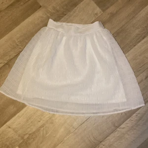 Vit kjol storlek 32 - Hej! Jag säljer denna otroligt fina kjol som är perfekt till sommaren! ❤️Aldrig använd. Köpt från HM i stl 32! ⚡️Hör gärna av er om ni har intresse för kjolen. Det står att den är avslutad men det är den inte 🤭