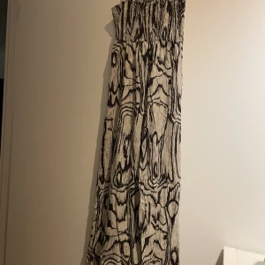 Klänning  - Lång klänning med axelband och draperad upp till Använd men i bra skick