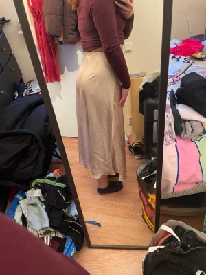 Beige satin kjol - Beige satin kjol med slit framtill från H&M. Storlek S. Aldrig använd.