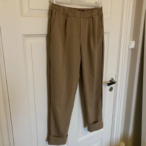 Byxor från Bershka - Säljer ett par snygga byxor från Bershka. Storlek M, passar som S. Resårband vid midjan. Uppvikta nedtill. 74% polyester,20% viskos och 6% elastan. I fint skick. 