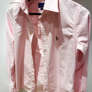Ralph Lauren skjorta  - Rosa-randig Ralph Lauren skjorta i storlek XS, lite tjockare linnetyg (100% bomull) använd 1 gång och säljes pga inte passar i rosa :( 
