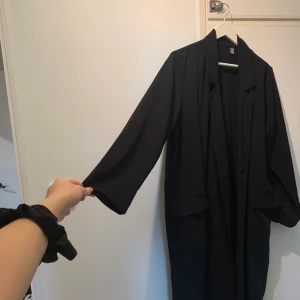Svart långkappa  - Använd några gånger, snygg till hösten. Ganska lång, går ovanför anklarna på mig som är 1.74 cm.