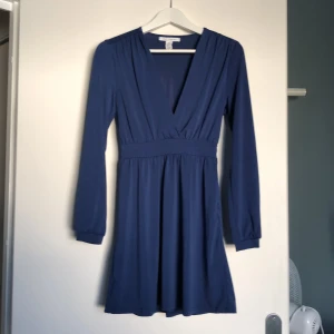 Nelly trend 36, marinblå - En marinblå klänning från Nelly trend i storlek 36. V-ringad och ner till strax över knäna på mig som är ca 160cm. Aldrig använd, endast provat innan den blev tvättad och inhängd i garderoben. 