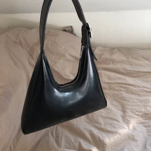 Svart handväska - Svart handväska från Carin Wester. Finns ett fack med dragkedja inuti. Materialet är glansigt, ”gummi”-aktigt. Köpt för 399kr. I nyskick!!💜💙