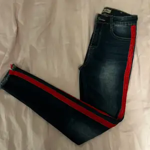 Blåa jeans med ett rött streck på sidan av benet. Storlek 36 enligt lapp men skulle säga att de är som 34. Från märket Blue rags. Använda ett par gånger. 