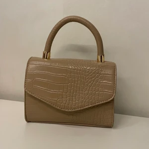 Söt väska ifrån primarkk - Gullig väska från primark som är använd få gånger💕 denna är så fin och kan användas genom att hålla den i handen i det lilla handtaget, eller använda det långa bandet och ha väskan korsad över kroppen/på axeln❣️ bandet är justerbart✨