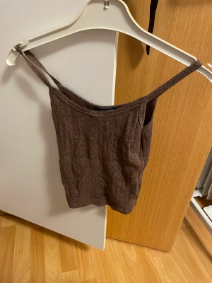 Skylar tank från Brandy Melville  - Skylar linne från Brandy Melville. Brunt med blommor på. Köpt dyrt på Depop. Passar XS till S