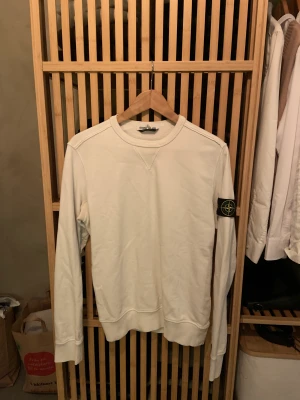 Stone Island tröja vit - Fint användt skick, använd väl utan några skador, lite mörkningar i armhålor. Köpt för några år sedan från hemsidan, finns tags och förpackning kvar. Fråga om du har funderingar.