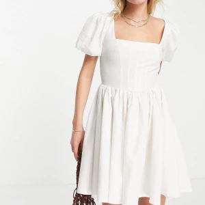 Vit skaterklänning med korsett detalj - En vit sakterklänning med korsett detalj och i typ linnetyg, Klänningen är aldrig använd, bara provad, med prislapp kvar, då den inte passar mig!! Den är i storlek eu 38 och skulle säga att den är normal i storlek. Den säljs till lite mindre än orginalpriset då den aldrig är använd men priset går att diskutera!! Skriv för bilder/frågor!!💕