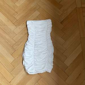 En vit axelbandslös klänning. Oanvänd