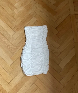 Miniklänning  - En vit axelbandslös klänning. Oanvänd