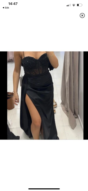 Klänning - Lång svart festklänning. Använd en gång och köpt för 4500kr. Passar till bal eller bröllop insydd i midjan, går att sprätta upp