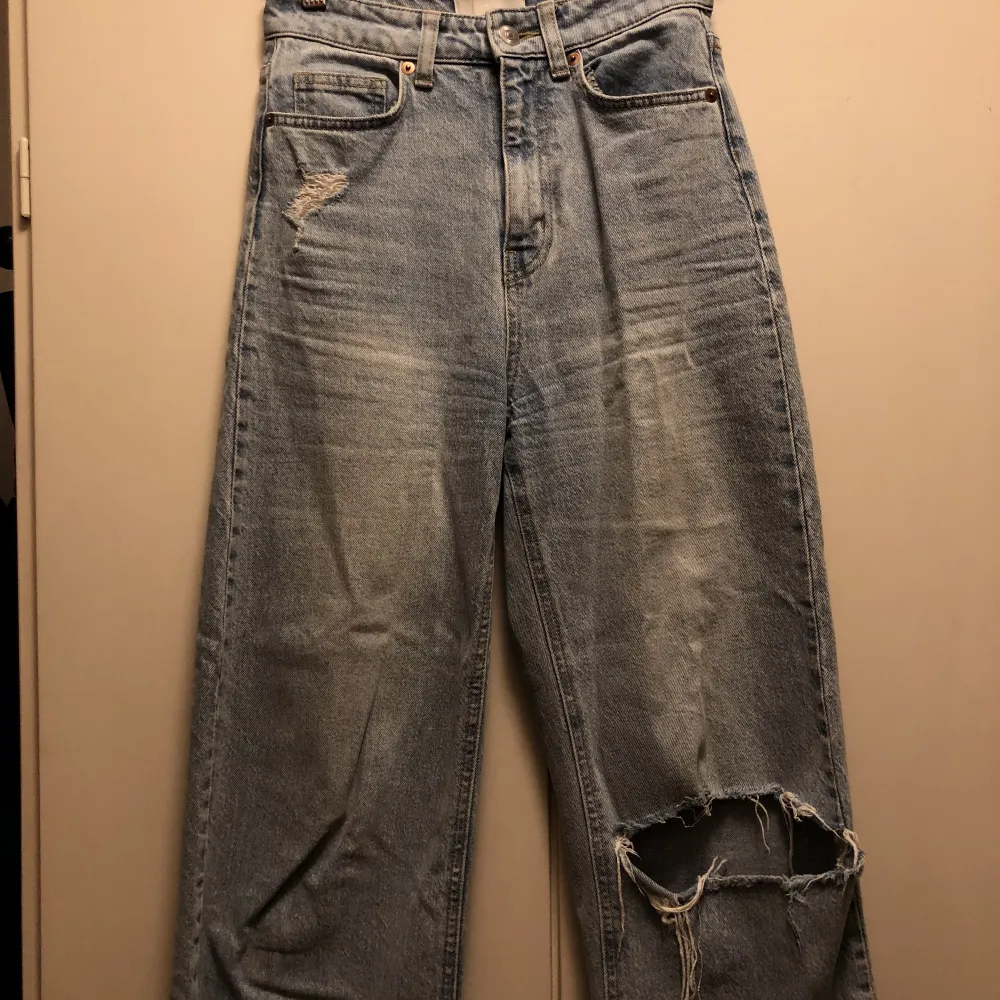 Högmidjade ljusblå jeans med hål från H&M. I ganska bra skick men hålet är lite slitet. Säljer eftersom att de inte passar min stil längre. . Jeans & Byxor.