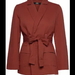 WACAY belted jacket - Bältad jacka i dovt vindöd färg från märket WACAY. Inköpt på Vallgatan 12. Skick: som ny, aldrig använd. Storlek: xs. Material yttertyg: 100% bomull. Innertyg: 60% bomull, 40% viskos. Säljer på grund av att den inte kommer till användning. Pris: 800kr