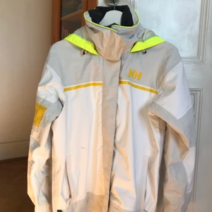 Helly Hansen regn och vindjacka - Helt i nyskick förutom ett märke på framsidan, syns på bild 1. Underbar kvalite, håller en varm och skön, fliskrage. 