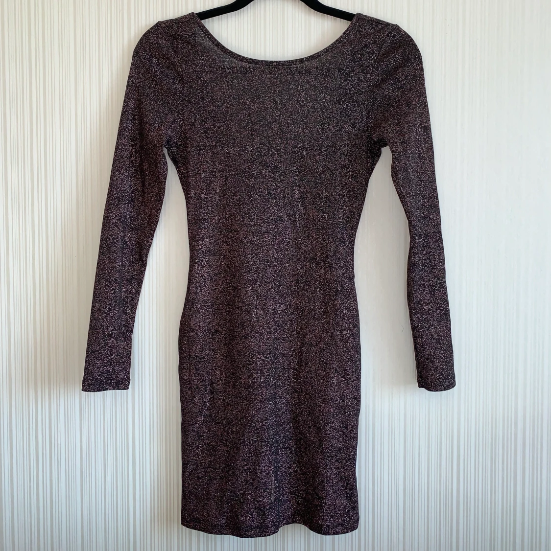 Rosa-/rödglittrig klänning.