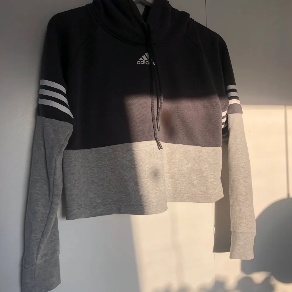 Croppad hoodie från Adidas i strl xs, fint skick men kommer tyvärr inte till användning . Hoodies.