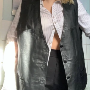 Oversize läderväst - Skitsnygg bikerinspirerad läderväst. Väldigt stor i passformen så den passar alla som vill ha en stor/oversize väst. Rött blankt innertyg. Inköpt från stadsmissionen. Inte använd :(❤️