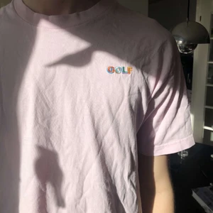 Rosa GOLF tshirt - En rosa GOLF tshirt med tryck i olika färger. Anledningen till att jag säljer är för att den inte kommer till användning hos mig
