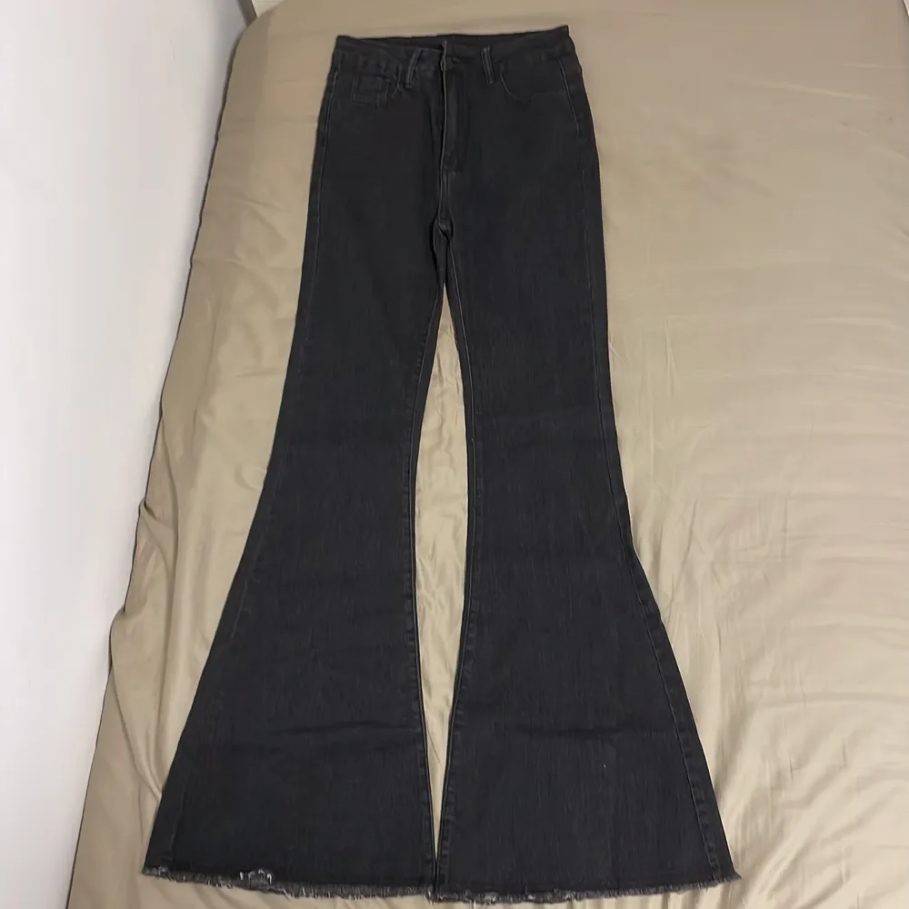 Ett par svarta, utsvängda jeans med storleken XS. Jag är XS men de blev ändå ganska långa på mig som man kan se i en av bilderna (jag är 159cm). De är köpta från SHEIN, vilket oftast inte har bra kvalite men den här hade  väldigt skön material. . Jeans & Byxor.