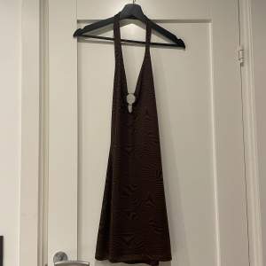 En mörkbrun klänning med nästan lite zebramönster och öppen rygg. Den kommer ursprungligen från H&M och jag har den i stl M. Har aldrig kommit till användning så den är i toppen skick! 