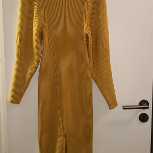 Gul stickad klänning - Oanvänd klänning i fint tjockt stickat material! Sitter fint på.  Små små trådar som sticker ut vid axeln men inget anmärkningsbart alls. Ord.499