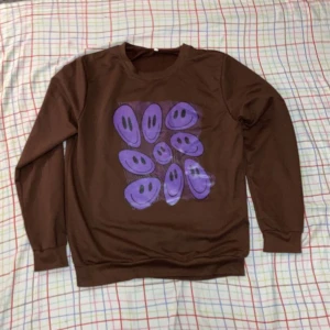 Brun tröja med lila ansikten - Köpt på shein 2021 för 149kr. Knappt använd och jag säljer den för att den inte kommer till användning.