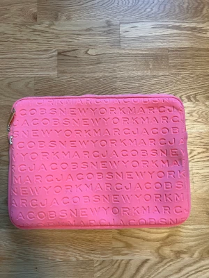 Datorfodral - Rosa datorfodral från Marc Jacobs. Inte alls sliten, är som i nytt skick. Köptes för 1200kr. 37x27 cm. Pris kan diskuteras vid snabb affär.