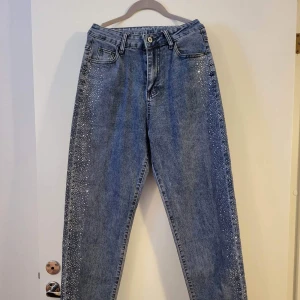 Jeans med glitter längst benen - helt nya byxor med glitter längst benen, storlek S-M. Hämtas i Upplands Väsby eller i Gamla Stan efter 16 på vardagar.