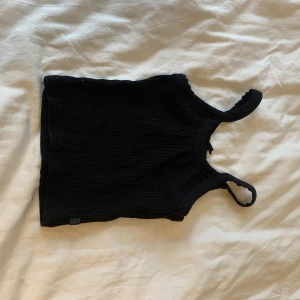 Svart linne - Linne från Cotton On Body. Väldigt liten i storleken. Ribbat tyg. Nyskick knappt använd