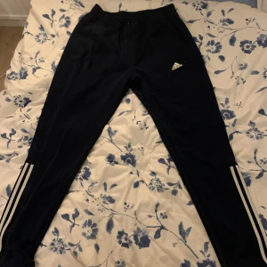 Adidasbyxor byxor - Mörkblå färg på byxorna. Strl M -L Endast 150 kr! Riktigt sköna byxor. Möts upp i sthlm för en slant extra, annars kan jag frakta med postnord :) 