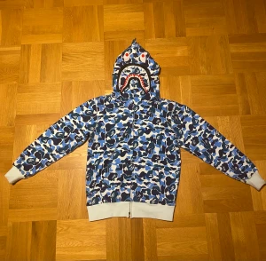 Bape hoddie  - Tja! Säljer nu min snygga bape hoddie som aldrig kommer till användning. Skick:8/10. Har tyvärr inga äkthetsbevis förutom att man kan se att hoddien är äkta pga tagsen osv! Hör av er vid frågor och funderingar! Pris kan diskuteras:) Tar byten dessutom!
