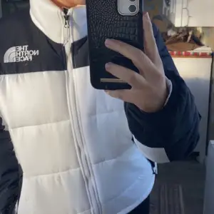 En vit och svart dunjacka från The North Face nästan som nyskick då jag inte använt den så mycket! Är i storlek M, men passar även om man brukar använda S då man kan ”spänna åt” nere på jackan. Hör av dig för fler eller bättre bilder:)  NYPRIS: 2600kr 