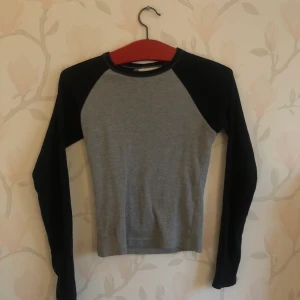 Raglan tröja - Svart och grå ribbad raglan tröja. Skön och sitter snyggt. Köpt på Asos.