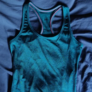 Elastisk Träning Tanktop - Mjuk elastisk träningstanktop ifrån HM i lätt skimmrig grön polyester. Aldrig använd. Storlek S. Skriv i chatt vid intresse. Möts upp i Hägersten