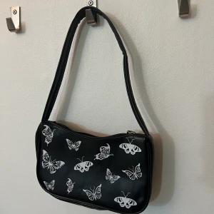 Väska med fjärilar - En svart axelväska med vita fjärilar på, ganska säker på att jag aldrig använt den