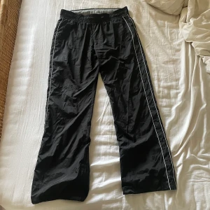 lågmidjat trackpants - Lågmidjade, vida trackpants från Nike! Storlek M, har snörning i midjan på insidan så kan anpassas.Säljer pga rensar garderoben för ska flytta utomlands, kolla min profil för fler liknande plagg ❣️ Först till kvarn!