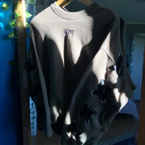 Sweatshirt med detalj - Supercool mörkgrön sweatshirt med snörning som går från ärm till ärm samt tryck fram där det står ”Hi Bye”! Strl S från H&M.