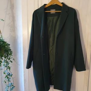 Kappa mörkgrön st XL - Stilig, mörkgrön kappa. Förvandlar din outfit till bussiness style samtidigt som den är avslappnad och bekväm. Inget slitage.