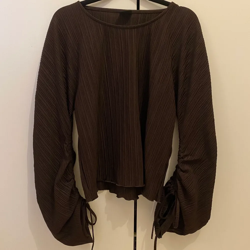Säljer en snygg brun tröja med en typ av ballongärm med knyt. Inköpt från Gina Tricot hösten 2021. Använd ett fåtal gånger och i mycket fint skick!. Toppar.