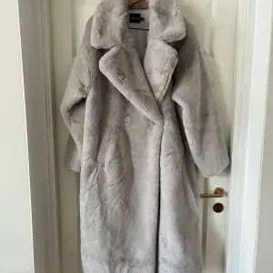 Kappa från Boohoo i faux fur. Skulle säga att den är ganska stor i storlek. Kappan är aldrig använd och har endast hängt i garderoben då jag inte hittat tillfälle att ha den. Den är lång, mjuk, varm och snygg!