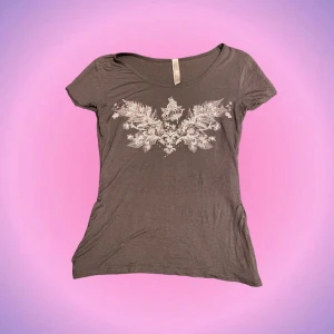 Brun T-shirt med tryck - Söt brun T-shirt med tryck och rhinestones! Har sytt in den så den sitter väldigt fint på😍🙌🏼 Skulle säga att den sitter som en S/XS nu när jag sytt in den! Den är i bra skick💖 Priset går att diskutera! Skriv privat vid intresse o frågor💋