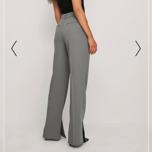 Gråa kostymbyxor med slits - Na-kd kostymbyxor. Knapp använda så de har inga defekter! Passar 36-38. Nypris: ca 500