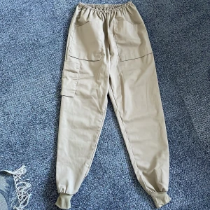 Beige Cargopants - Begie cargopants som tyvärr inte sitter som jag vill på mig:/ lite för tajta över låren på mig. Storlek M men det är resår i midjan så passar alla beroende på hur man vill att dom ska sitta.