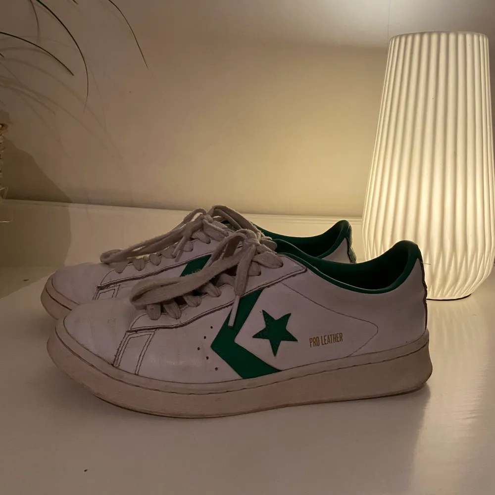Vita Converse sneakers med gröna detaljer. Så fina och sköna att gå i! Inga större defekter förutom de slitage man kan förvänta sig. Storlek 40, köparen står för frakt🥰. Skor.
