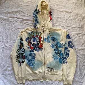 Äkta Ed hardy zipup hoodie - AVSLUTAD! VINNANDE BUD: 630 + FRAKT!⭐️ Snygg ed hardy zip up hoodie med tryck. Bra skick förutom två enstaka kristaller som ramlat av där bak men märks ej av. Storlek L på lapp men passar flera storlekar. Köparen står för frakt. ❤️